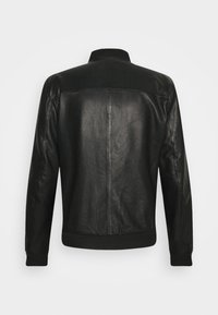 Svart skinnjacka med en slät yta, ribbad krage och manschetter, figurnära design och ryggparti med detaljer.