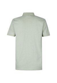 Polo shirt verde chiaro a maniche corte con colletto, caratterizzato da una finitura testurizzata e piccole macchie sparse in tutto il tessuto.