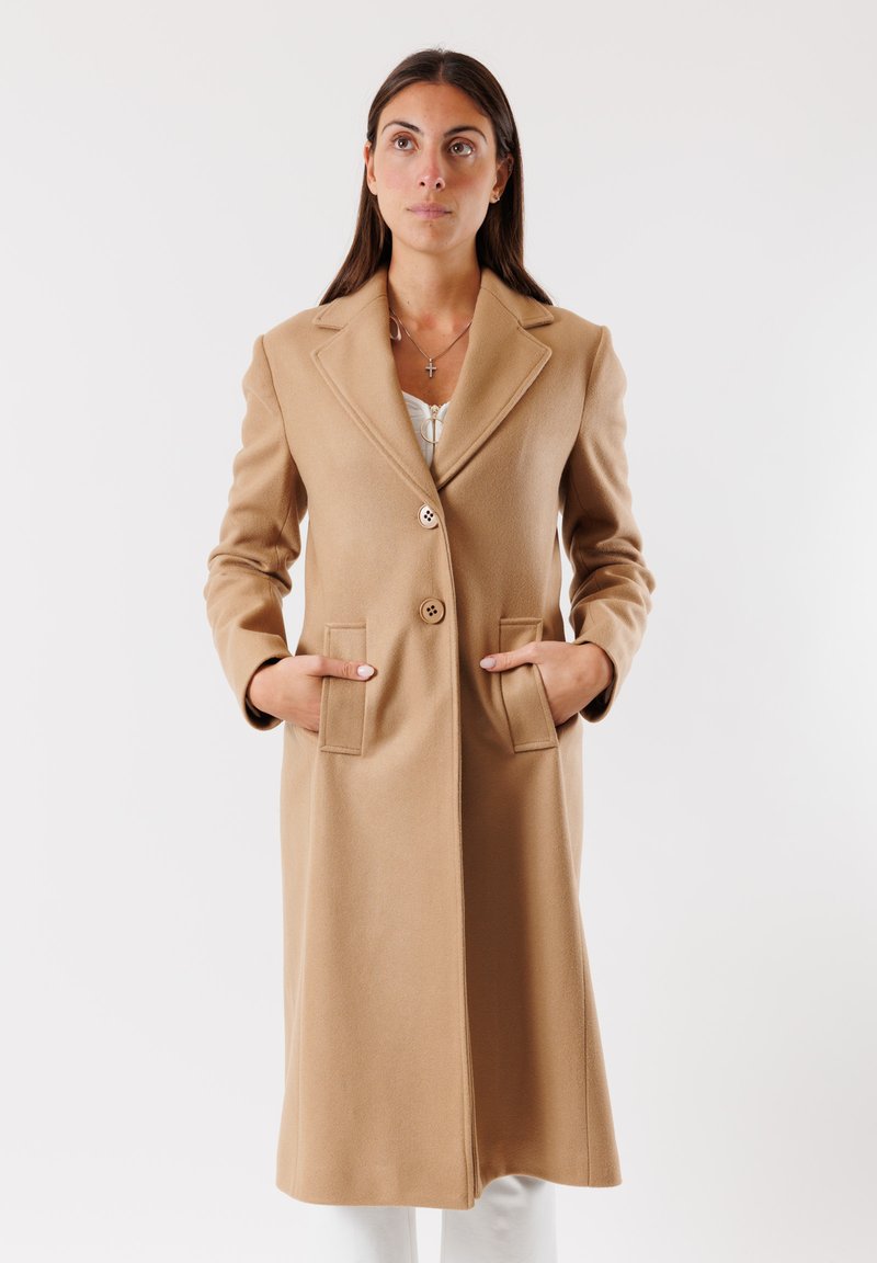 Cappotto in misto lana beige con design lungo, rever a notched, due tasche anteriori e due bottoni. Texture liscia con vestibilità tailored.