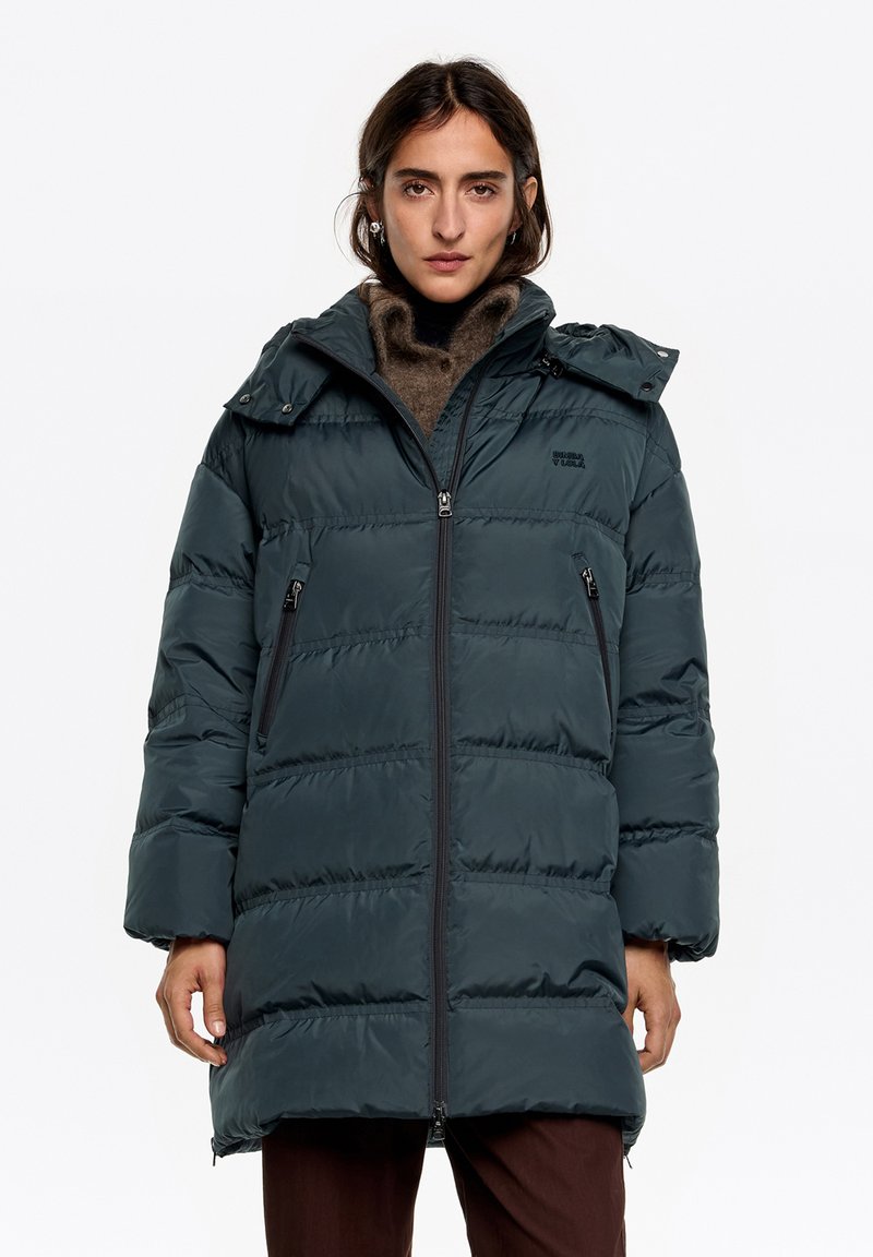 Długa, pikowana kurtka w ciemnozielonym kolorze, z zamkiem błyskawicznym, bocznymi kieszeniami oraz odpinanym kapturem o gładkim, błyszczącym wykończeniu.