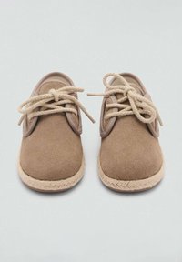 Braune Wildlederschuhe mit beigen Baumwollsenkeln, runder Zehenform und einer strukturierten, geflochtenen Sohle. Glatte Kragenakzente kontrastieren mit dem Obermaterial.