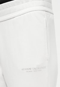 Λευκά βαμβακερά παντελόνια τζόγκινγκ με ριμπ ζώνη μέσης και διακριτικό λογότυπο. Διαθέτουν πλαϊνή τσέπη και απαλή υφή.