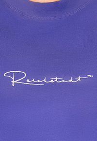 Paars geribbeld stof met een hoge halslijn, voorzien van witte geborduurde tekst die "Reuchstadt" leest. Eenvoudig en aansluitend ontwerp.