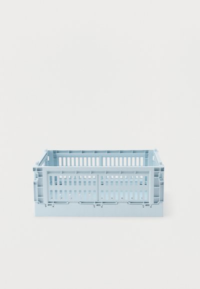 Ανοιχτό μπλε πλαστικό πτυσσόμενο κιβώτιο με εξαερισμένες πλευρές και βάση, κενό και τοποθετημένο σε λευκή επιφάνεια.