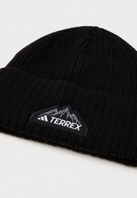 Czarna, prążkowana czapka beanie z zawiniętą mankietą, z trójkątną łatką z motywem górskim oraz napisem "TERREX".