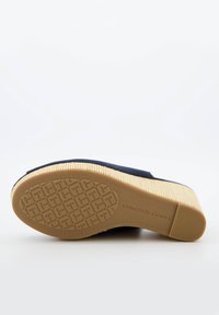 Shoe slip-on navy con tomaia in tessuto testurizzato e suola in gomma decorata con logo in rilievo. Accentuato con una suola di colore chiaro.