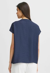 Maglietta girocollo blu navy a maniche corte con tessuto testurizzato, vestibilità comoda, orlo dritto e vista da dietro.