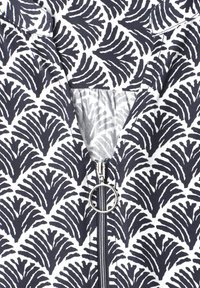 Gros plan d'un tissu à motifs noir et blanc avec une fermeture éclair dotée d'une languette ronde en métal.