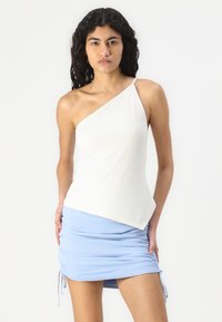 White asymmetric tank top with a single strap, paired with a light blue ruched mini skirt featuring drawstrings on the sides.