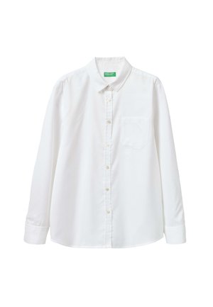 Camicia bianca con bottoni realizzata in un tessuto liscio, con colletto, maniche lunghe e una tasca sul petto. Dettaglio di texture sottile.