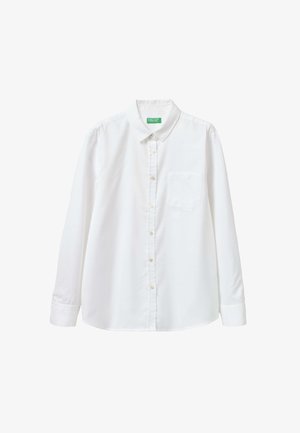 Camisa blanca de botones, hecha de una tela suave, con cuello, mangas largas y un único bolsillo en el pecho. Detalle de textura sutil.