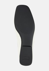 Schuhsohle aus einem strukturierten schwarzen Gummimaterial, mit einer glatten weißen Kante und einem rechteckigen Akzent an der Ferse für Griff und Design.