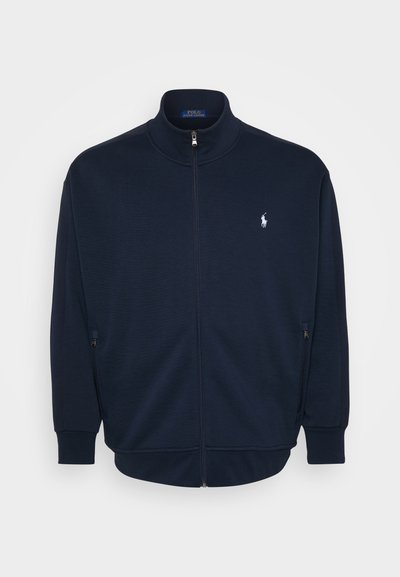 Sweatshirt azul-marinho com fecho, feito de um tecido suave, apresentando um colarinho alto, bolsos laterais, punhos e bainha canelados, com um pequeno logótipo no peito.