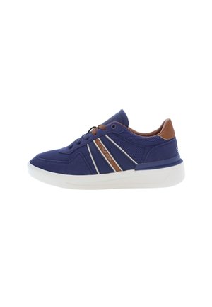 Marinblå sneaker med bruna detaljer; ovandel i mesh och syntetmaterial, gummisulor och vit mellansula. Har tre diagonala ränder och rund snörning.