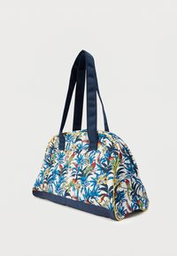 Πλεκτή τσάντα με τροπικό λουλουδένιο και πουλί μοτίβο σε μπλε, πράσινο και κίτρινο. Διαθέτει λουράκια από ναυτικό ύφασμα και κίτρινο τελείωμα.