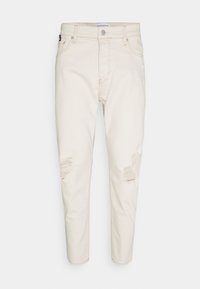 Světle béžové džíny z denimu s opranými detaily, pěti kapsami, zapínáním na knoflík a tapered střihem. Hladká textura s jemným leskem.