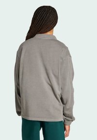 Grå bomulds sweatshirts med en afslappet pasform, har en krave, ribbede manchetter og en glat tekstur, set fra ryggen.