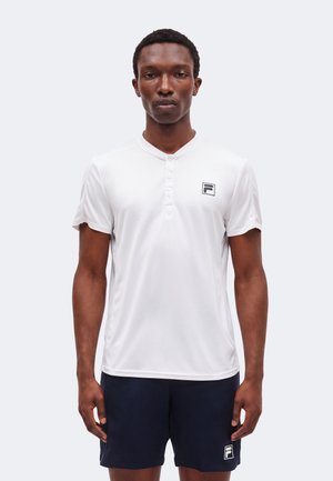 Mand iført en hvid kortærmet Henley-shirt og marineblå shorts, begge med et sort-hvidt logo på brystet og låret.