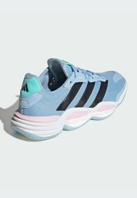 Zapatilla deportiva de color azul claro con parte superior de malla, diseño de tres rayas en negro, acentos en verde menta, suela intermedia rosa y detalle texturizado en el talón.