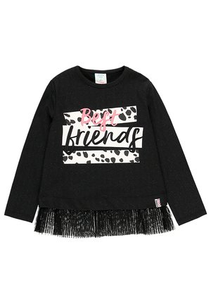 Chemise noire à manches longues avec texte rose et noir "Best friends" sur des rayures blanches et noires tachetées et une bordure en tulle noir à l'ourlet.