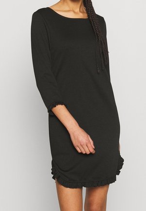 Schwarzes Kleid mit Dreiviertelärmeln und rundem Ausschnitt. Verfügt über einen rüschengesäumten Saum und Ärmelenden. Hergestellt aus weichem, dehnbarem Material.