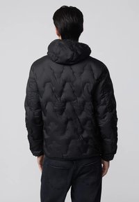 Giacca a vento nera con cappuccio, caratterizzata da un motivo a rombi trapuntato e polsini elasticizzati. Il materiale sembra liscio e resistente all'acqua.