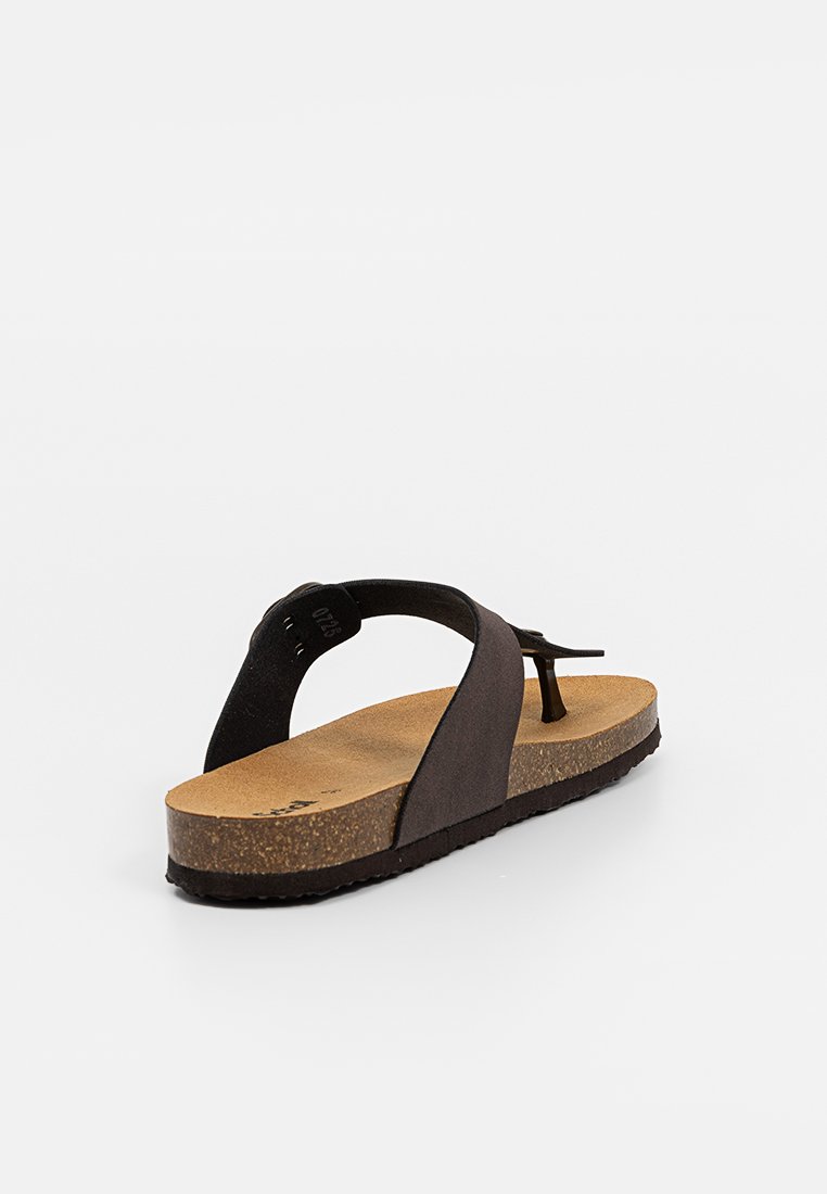 Sandale à semelle en liège brun avec une lanière en cuir noir et une large bande noire traversant le pied, vue en angle montrant le profil arrière et latéral.