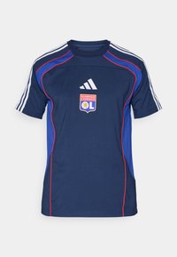 Marineblauw sportshirt met rode accenten, drie witte strepen op de schouders, met het logo van Olympique Lyonnais op de voorkant.