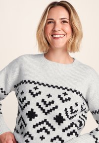 Light gray knit sweater with black geometric patterns; ribbed texture, crew neckline, and long sleeves. Casual design suitable for layering.