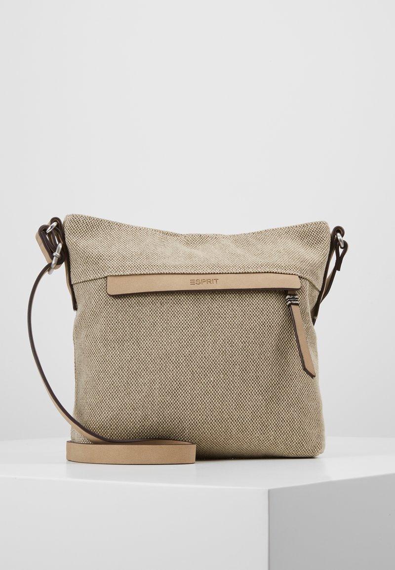 Beige axelväska i canvas med läderrem, försedd med dragkedja upptill och en fram panel i läder med präglad logotyp.