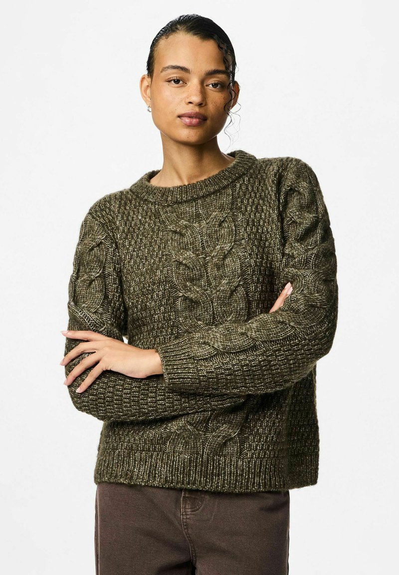 Tume rohelise värvi sooniku muster, ümar kaelus ja tekstuurne muster, ribaga mansetid. Varraste ääres on suured kaablisegmendid.