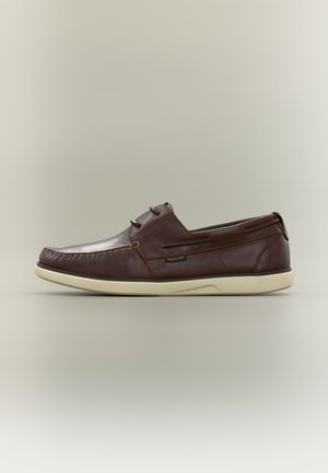 Chaussure bateau en cuir marron avec lacets, couture texturée, semelle crème et accents latéraux. Présente un bout arrondi et un design sans lacets.