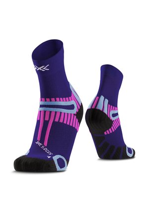 Paarse sportsokken met zwarte tenen en hielen, met roze en lichtblauwe geometrische patronen en een wit logo nabij de tenen en boorden.