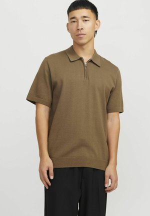 Polo închis la culoare cu mânecă scurtă, cu guler cu fermoar, textură ribbată și o croială lejeră, asortat cu pantaloni negri.