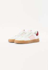 Nizki športni copati iz belega usnja z rožnatimi in rdečimi detajli. Imajo gumijast podplat in sistem vezalk. Uporabljeni so teksturirani materiali.