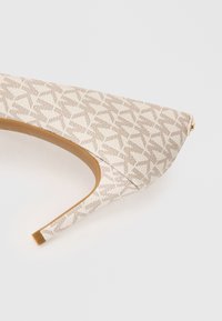 Scarpa con tacco alto beige con tomaia in tessuto a motivo, punta appuntita e silhouette elegante e slanciata. Suola in pelle con finitura opaca.