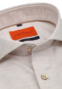 Beige slim-fit overhemd met een gestructureerde stof, voorzien van een kraag met knopen en crèmekleurige knopen. Het label zegt "SUITABLE" in oranje.