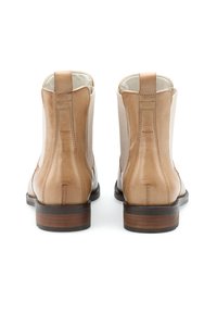 Tan leather ankle boots with elastic side panels, rounded toe, and a stacked wooden heel. Back features a seam with decorative stitching.