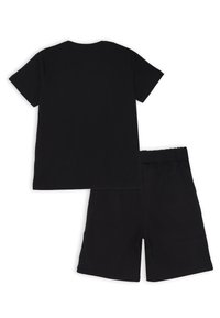 T-shirt in cotone nero con scollatura rotonda e maniche corte abbinato a pantaloni corti in cotone nero con cintura elastica.