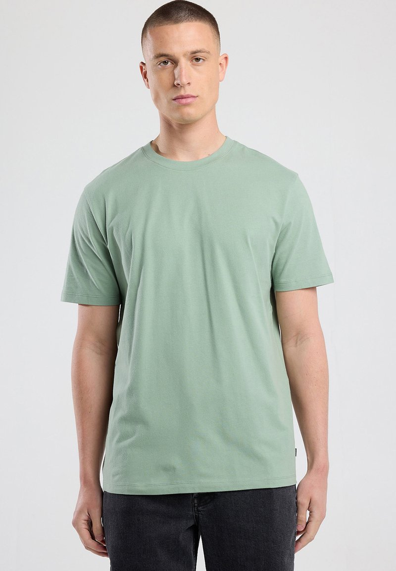 Light green short-sleeve T-shirt in soft, breathable fabric. Features a round neckline and relaxed fit with no visible patterns or graphics.