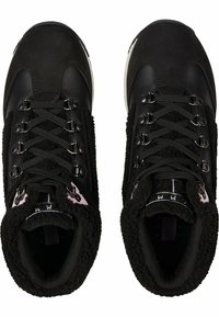 Zapatos negros con un upper texturizado y esponjoso, puntera de cuero suave, seis ojales y cordones negros. Acento rosa en contraste cerca de la lengüeta.