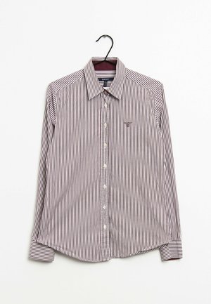 Pasiasta, długosleeve koszula w ciemnoczerwonym i białym kolorze z bawełny. Posiada zapięcie na guziki z przodu, spiczasty kołnierzyk i małe logo na lewej piersi.