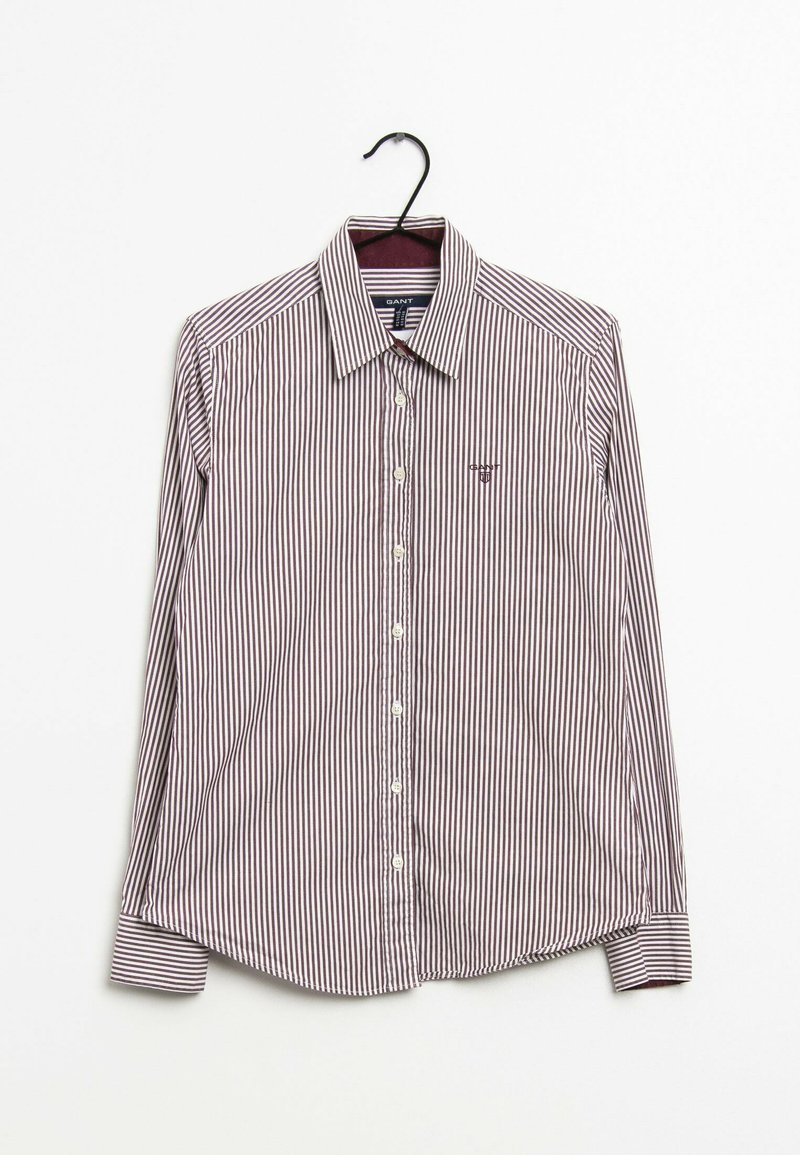 Gestreiftes Langarmhemd aus dunkelroter und weißer Baumwolle. Verfügt über eine durchgehende Knopfleiste, einen spitzen Kragen und ein kleines Logo auf der linken Brust.