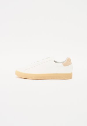 White sneakers made of smooth leather with a beige suede heel accent and a light tan rubber sole, featuring classic lace-up design.