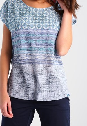 Kortoude top met een patroon in blauw en groen, met horizontale strepen en een textuur in het onderste gedeelte. Ronde halslijn en een relaxte pasvorm.