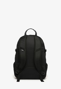 Schwarzer Rucksack mit gepolsterten Trägern, strukturiertem Stoff, verstellbaren Schnallen und einem oberen Griff zum Tragen. Besitzt Seitentaschen und ein Logo-Detail.
