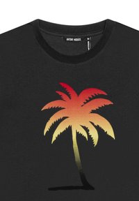 Camiseta negra con un diseño de palmera en degradado en rojo y naranja sobre un fondo texturizado. La etiqueta dice "ANTHONY MORATO."
