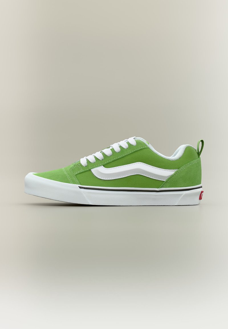 Πράσινο παπούτσι τύπου low-top με λευκά κορδόνια, λευκή πλαϊνή ρίγα και λευκή σόλα με μαύρη ρίγα, παρουσιάζεται σε προφίλ σε ουδέτερο φόντο.