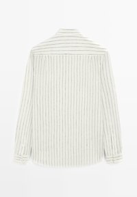 Wit shirt met lange mouwen en verticale zwarte krijtstrepen, met knoopmanchetten en een klassieke kraag, gezien van achteren op een witte achtergrond.