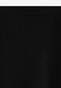 Leggings negros hechos de tela suave y elástica con un diseño liso y una cintura acanalada, sin patrones ni detalles visibles.